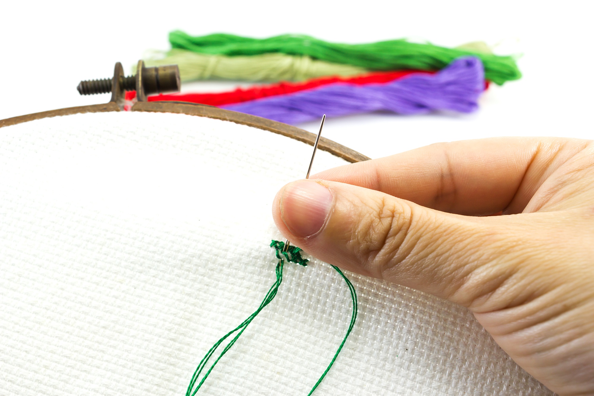 close up of hands embroidering a patch
